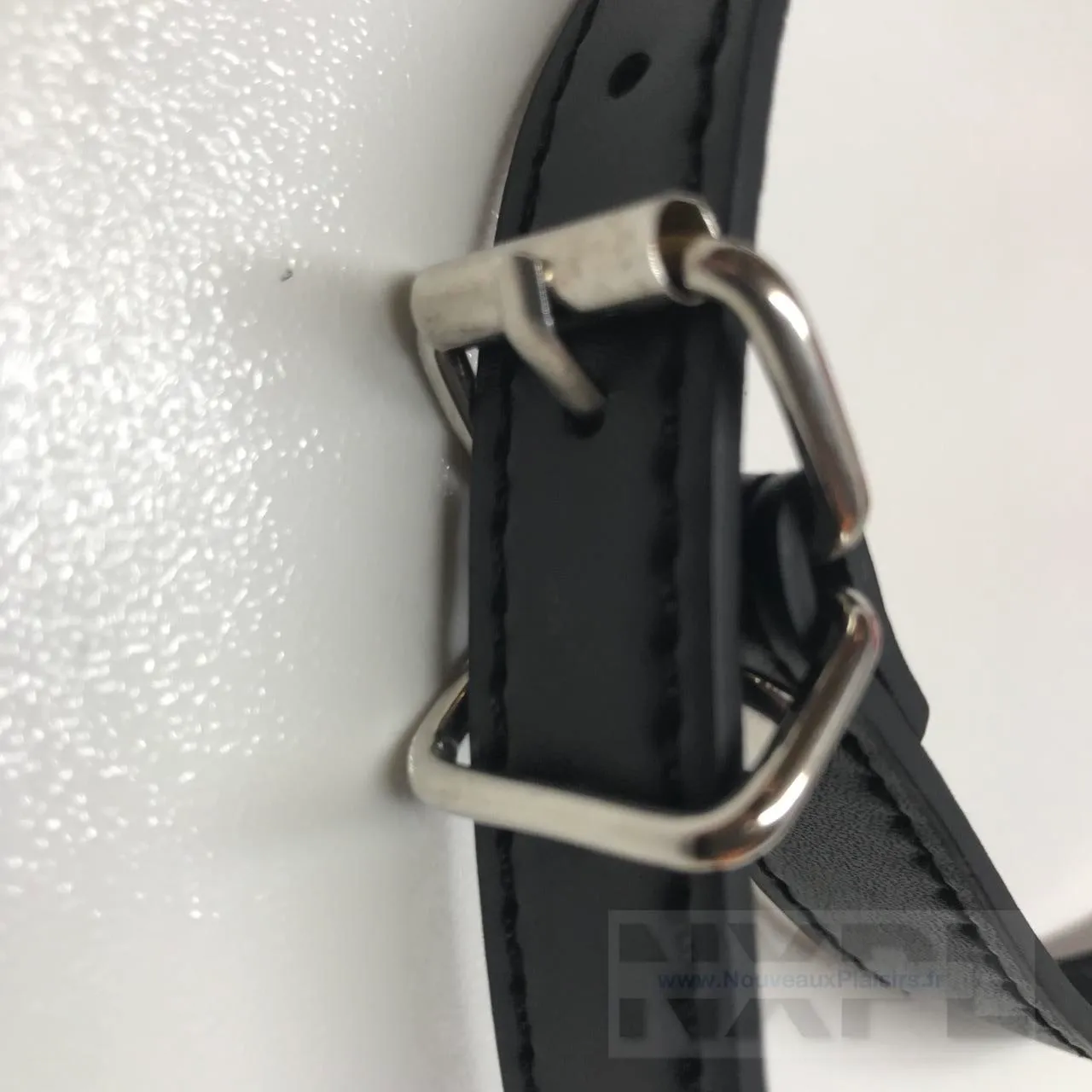 Gros plan sur la boucle en cuir et métal du bâillon lèvres rouges