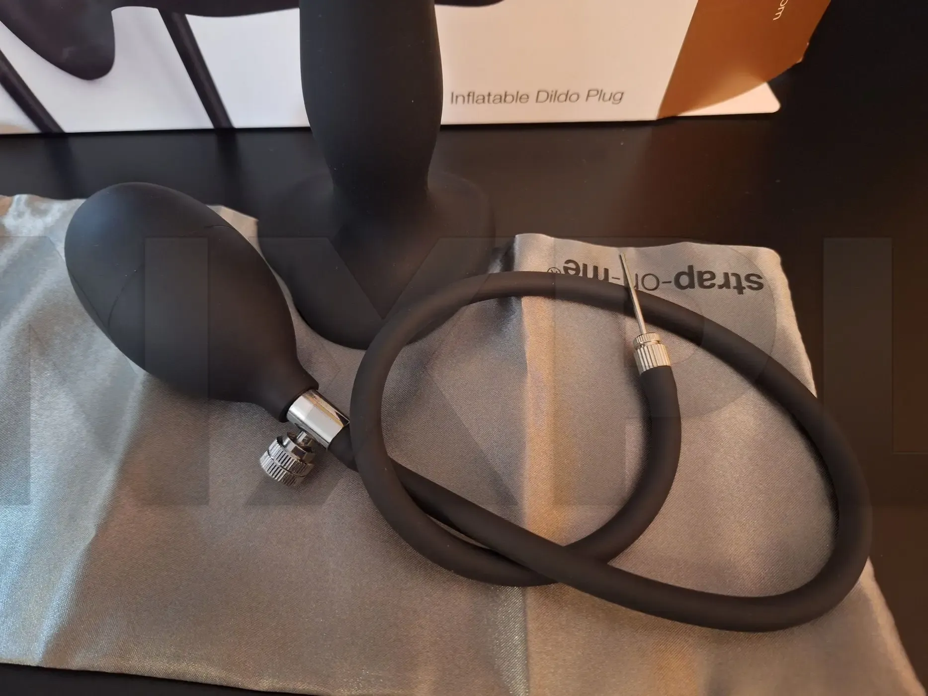 Inflatable Dildo Plug Strap On Me noir de la Hybrid Collection, plug anal gonflable en silicone avec poire de gonflage et tuyau amovible, sur fond sombre, testé sur nouveauxplaisirs.fr pour stimulation anale et vaginale intense et originale.