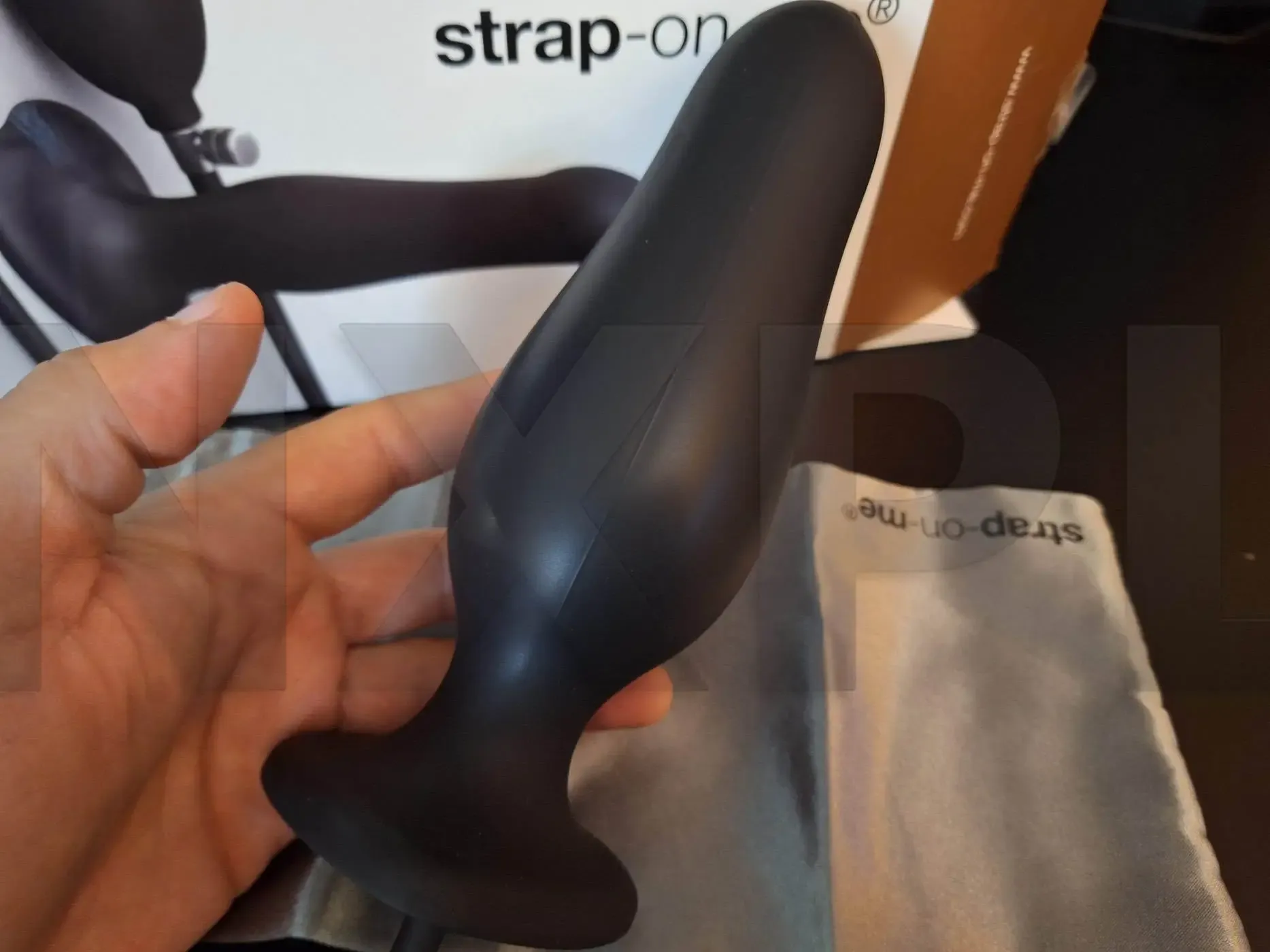 Inflatable Dildo Plug Strap On Me noir de la Hybrid Collection, plug anal gonflable en silicone avec poire de gonflage et tuyau amovible, sur fond sombre, testé sur nouveauxplaisirs.fr pour stimulation anale et vaginale intense et originale.
