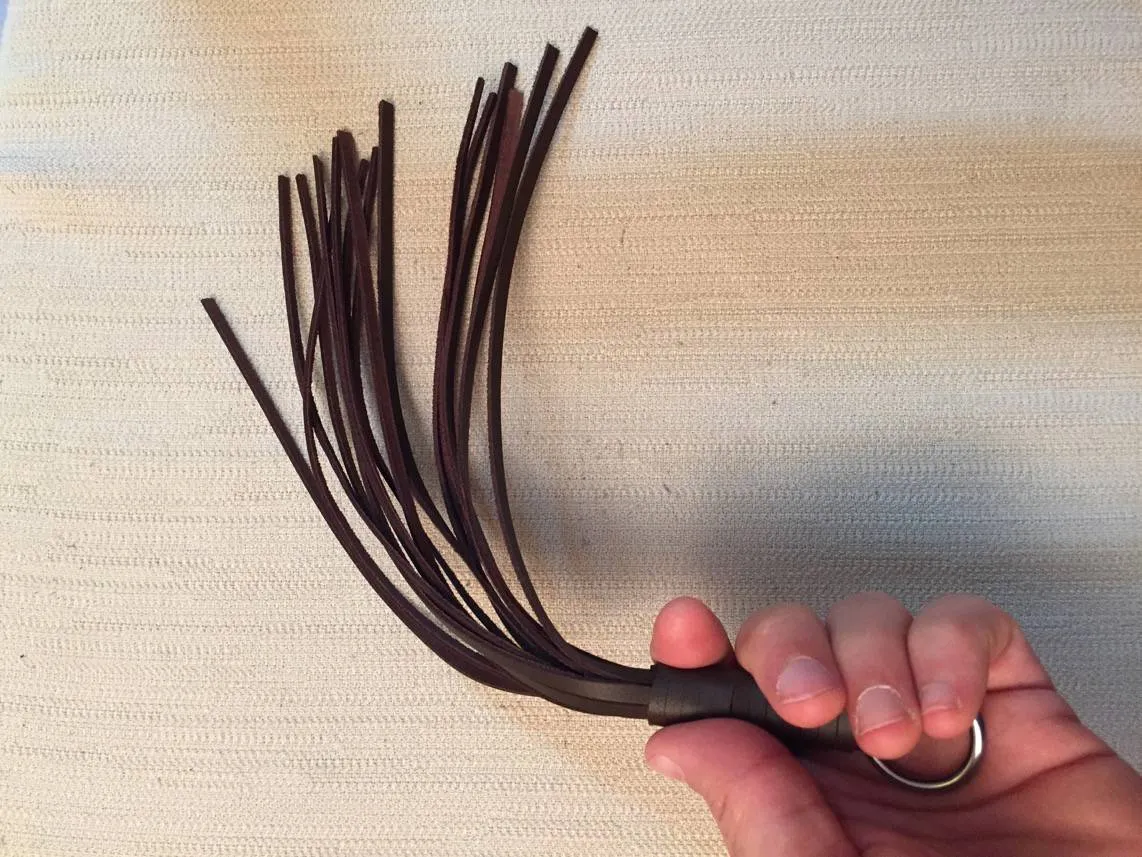 Petit martinet en cuir marron Dèmonia tenu en main